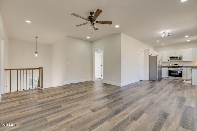 unfurnished living room featuring baseboards, ceiling fan, light wood-type flooring, and recessed lighting