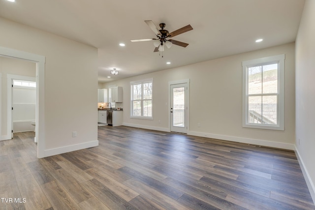 unfurnished living room with dark wood-style floors, recessed lighting, and baseboards