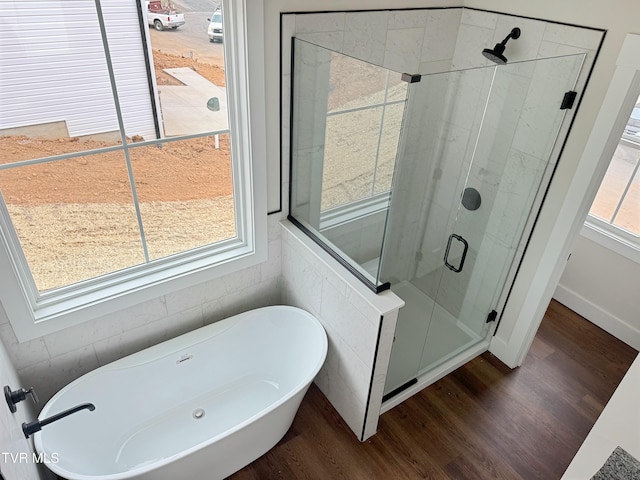 bathroom featuring a freestanding tub, wood finished floors, and a stall shower