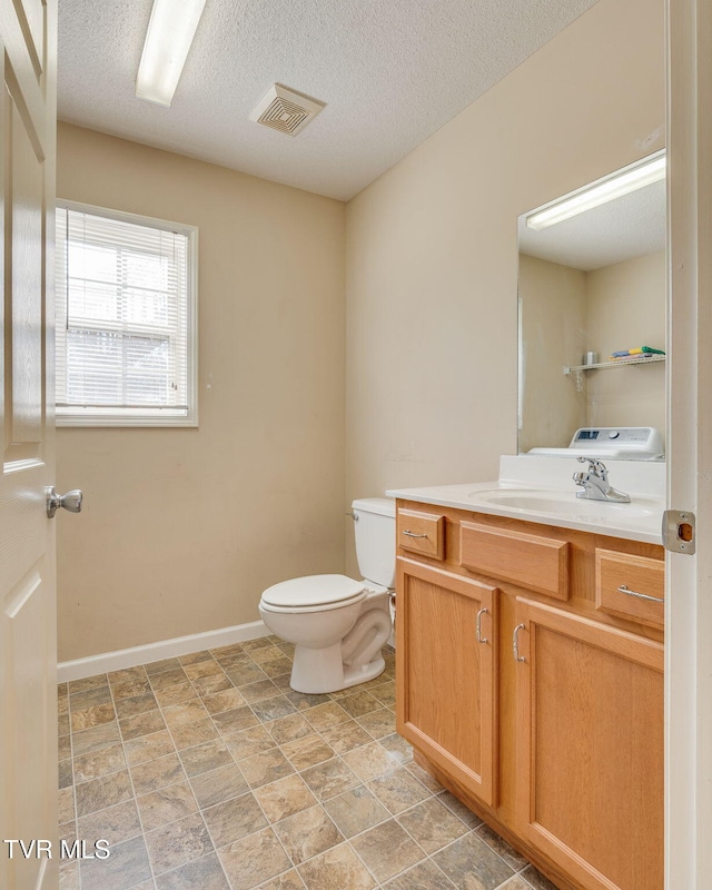 bathroom featuring a textured ceiling, toilet, and vanity