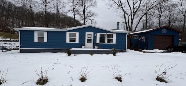 view of front of property featuring an outdoor structure and a garage