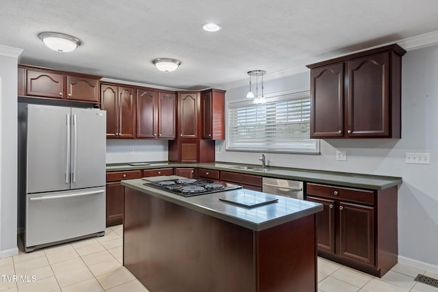 kitchen featuring light tile patterned floors, appliances with stainless steel finishes, a kitchen island, decorative light fixtures, and ornamental molding