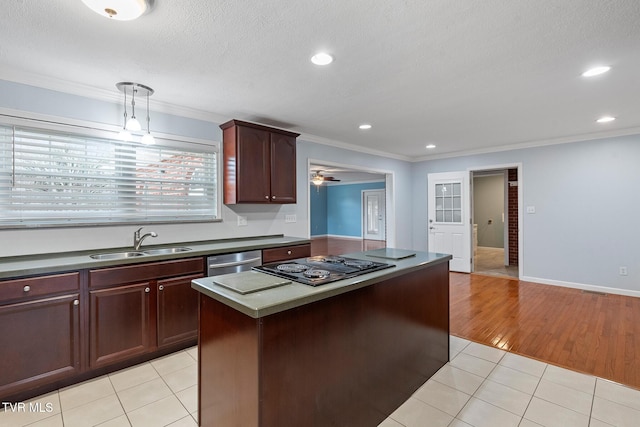 kitchen with light tile patterned floors, black electric cooktop, dishwasher, crown molding, and sink