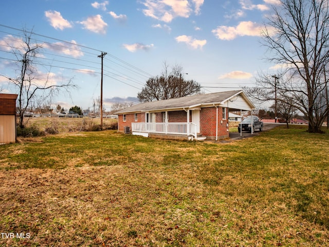 view of side of property with a lawn, a porch, and a carport