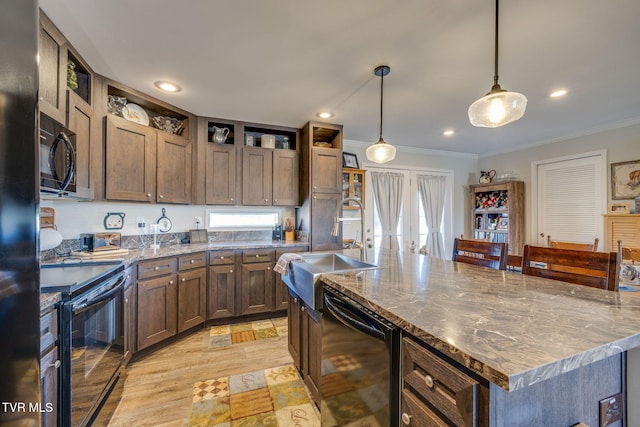 kitchen with black appliances, decorative light fixtures, a kitchen island, and crown molding