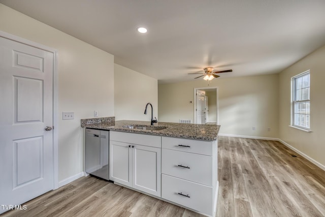 kitchen with white cabinetry, sink, stone countertops, kitchen peninsula, and stainless steel dishwasher