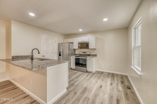 kitchen featuring a sink, light wood-style flooring, white cabinets, and stainless steel appliances