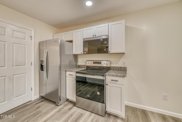 kitchen with appliances with stainless steel finishes, light hardwood / wood-style floors, white cabinetry, and light stone countertops