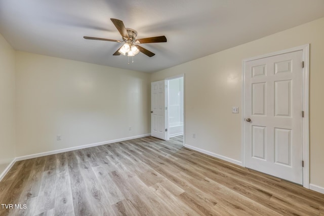 empty room with baseboards, ceiling fan, and light wood finished floors