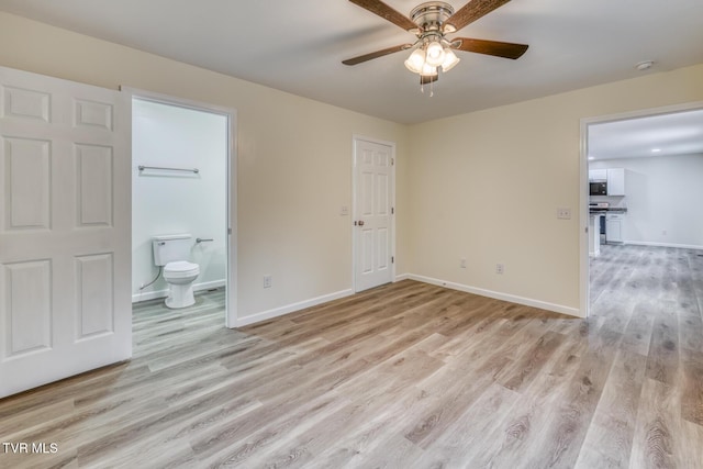 unfurnished bedroom featuring ceiling fan, baseboards, light wood-type flooring, and connected bathroom