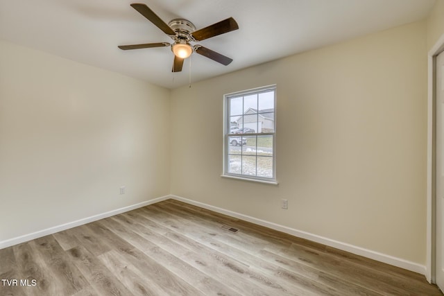 empty room featuring visible vents, baseboards, light wood-style floors, and ceiling fan