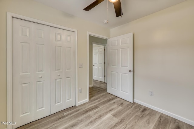 unfurnished bedroom featuring light wood finished floors, baseboards, and a closet