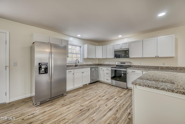 kitchen featuring light stone counters, sink, white cabinets, and stainless steel appliances