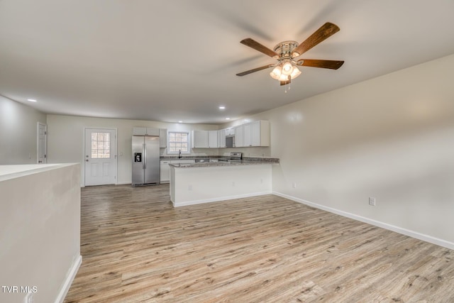 unfurnished living room featuring light wood-type flooring and ceiling fan