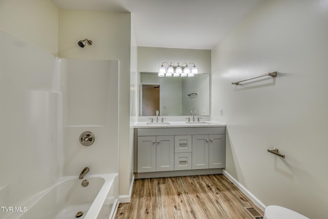 bathroom featuring wood-type flooring, bathtub / shower combination, and vanity