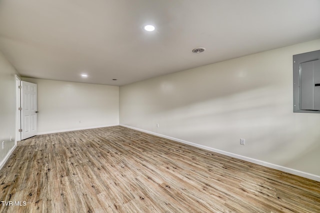 empty room with electric panel and light hardwood / wood-style flooring