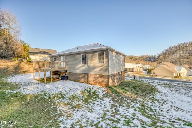 snow covered rear of property featuring a deck