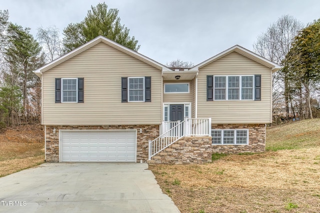 bi-level home with an attached garage and concrete driveway