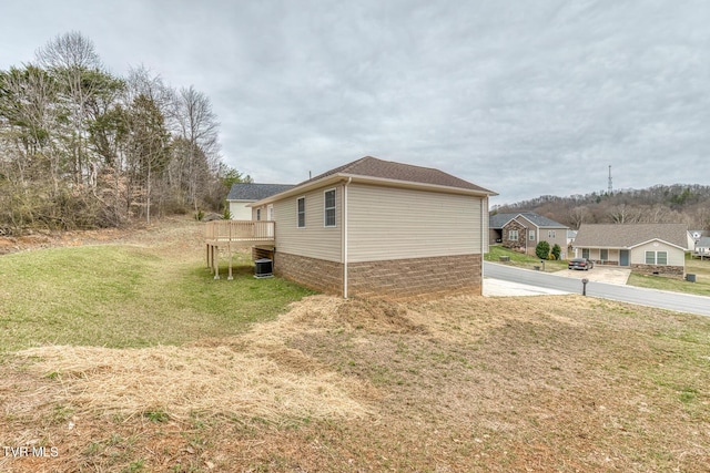 view of property exterior with a deck and a yard