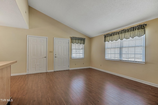 foyer with vaulted ceiling, a textured ceiling, and hardwood / wood-style flooring