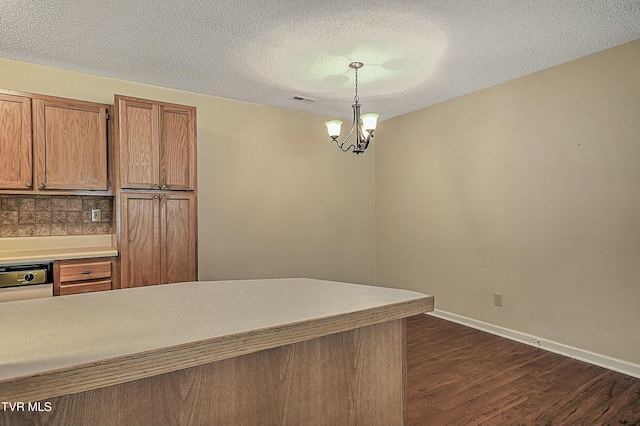 kitchen with backsplash, dark hardwood / wood-style flooring, hanging light fixtures, a textured ceiling, and a chandelier