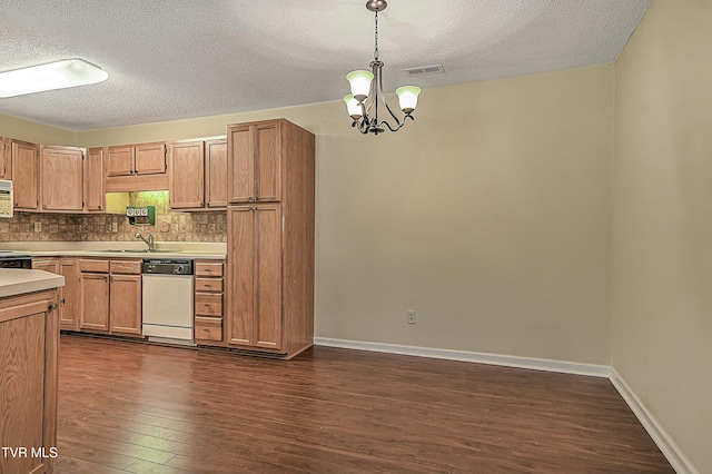 kitchen with dishwasher, dark hardwood / wood-style floors, sink, hanging light fixtures, and a textured ceiling