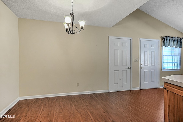 interior space with vaulted ceiling, dark hardwood / wood-style floors, and a textured ceiling