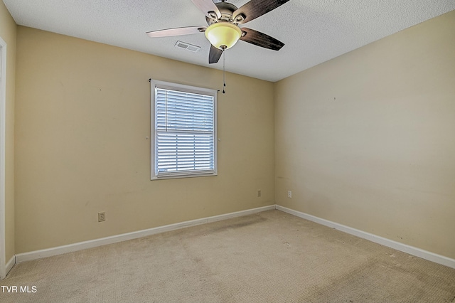 carpeted spare room featuring ceiling fan and a textured ceiling