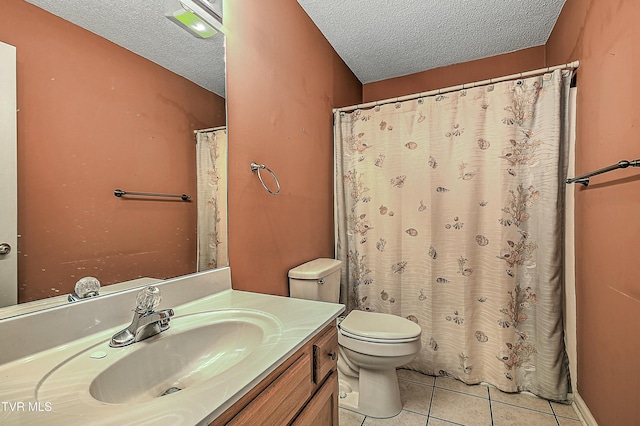 bathroom with a textured ceiling, toilet, vanity, and tile patterned flooring