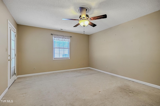 carpeted spare room featuring ceiling fan and a textured ceiling