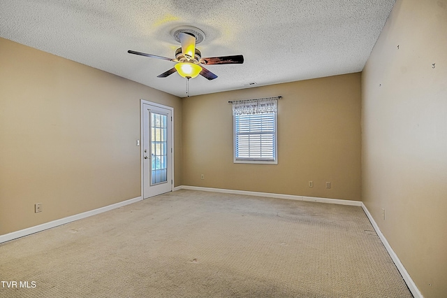 empty room featuring a textured ceiling, ceiling fan, and carpet flooring