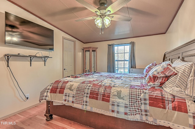 bedroom featuring crown molding, hardwood / wood-style flooring, vaulted ceiling, and ceiling fan