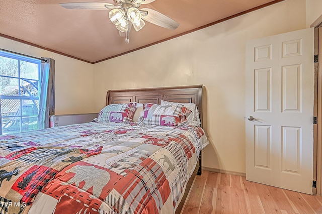 bedroom featuring ornamental molding, ceiling fan, and light wood-type flooring