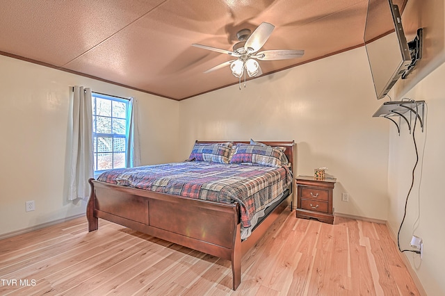 bedroom with ornamental molding, a textured ceiling, ceiling fan, and light wood-type flooring