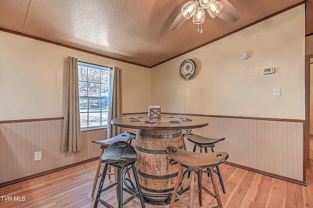 dining room featuring ceiling fan, light hardwood / wood-style floors, and a textured ceiling