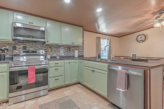 kitchen featuring sink, backsplash, stainless steel appliances, and green cabinetry