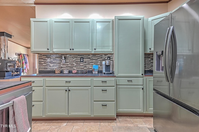 kitchen featuring stainless steel refrigerator with ice dispenser, backsplash, and green cabinetry