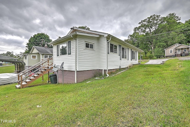 view of side of property with a lawn and a carport