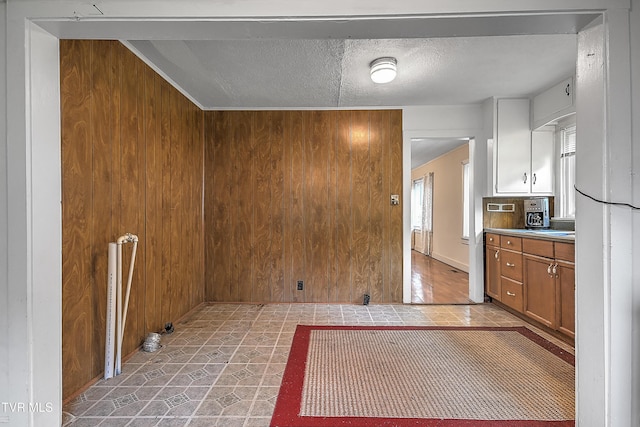 kitchen featuring a textured ceiling and wood walls