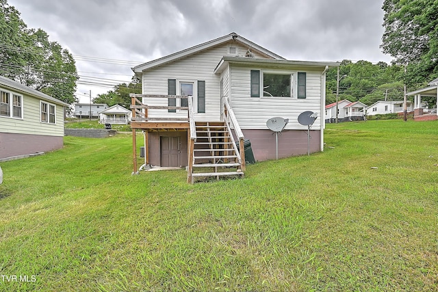 rear view of house featuring a deck and a lawn