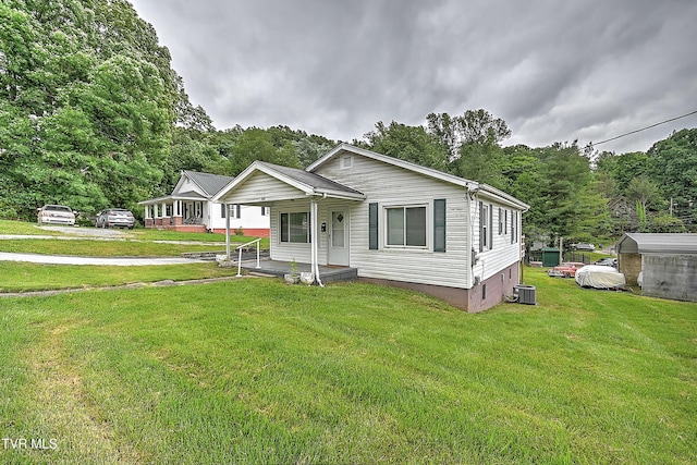 view of front of house with a front lawn, central AC unit, and a porch