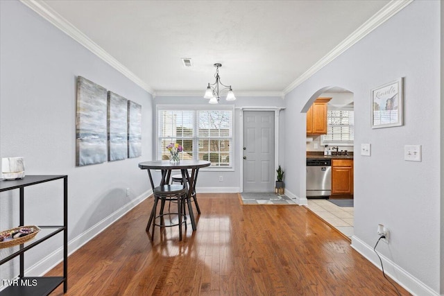 dining space featuring ornamental molding, a chandelier, and light wood-type flooring