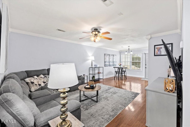 living room featuring ceiling fan with notable chandelier, wood-type flooring, and crown molding