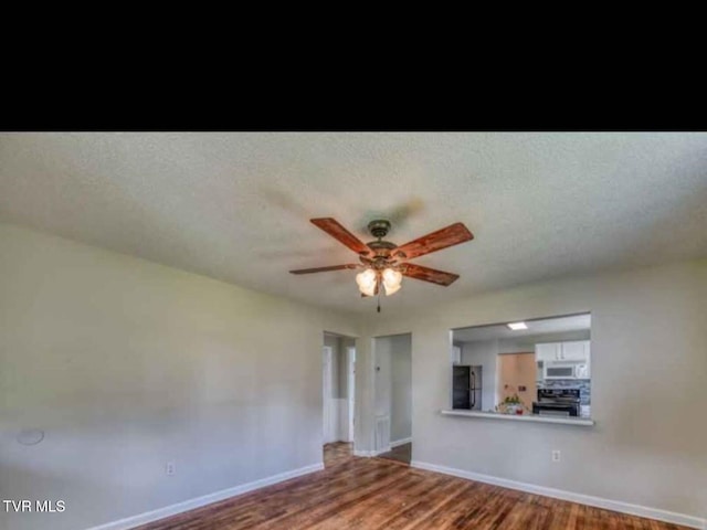 unfurnished living room featuring a textured ceiling and hardwood / wood-style floors