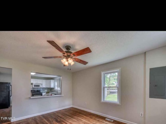 unfurnished living room with ceiling fan, hardwood / wood-style flooring, and electric panel