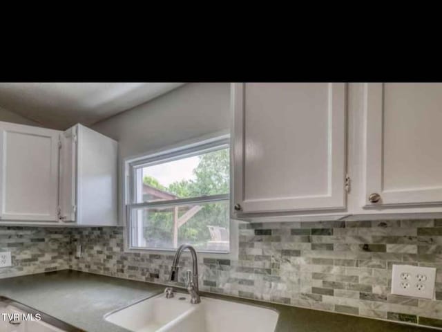 kitchen featuring white cabinetry, decorative backsplash, and sink