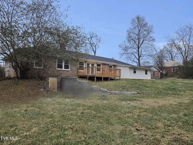 back of house with a deck and a lawn