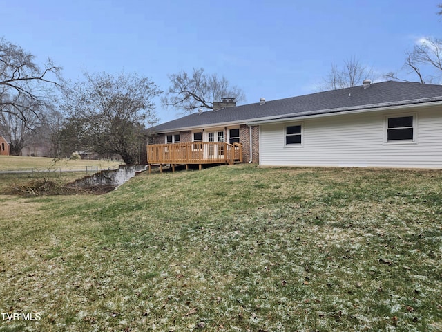 rear view of house with a deck and a lawn