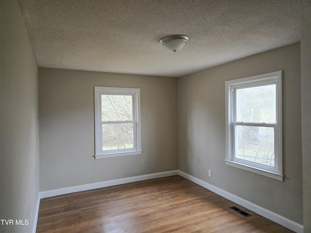 empty room featuring hardwood / wood-style flooring and a textured ceiling