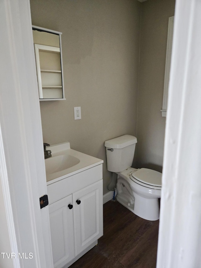 bathroom with vanity, toilet, hardwood / wood-style floors, and built in features